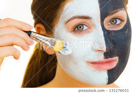 Girl black mask on half face apply white mud 135276031