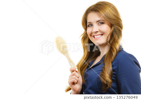 Woman brushing long healthy brown hair Woman brushing long healthy brown hair 135276049