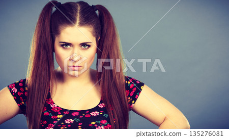 Angry teenager girl with brown hair ponytails 135276081
