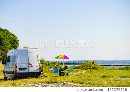 Umbrella with chairs at campervan on beach Umbrella with chairs at campervan on beach 135276326