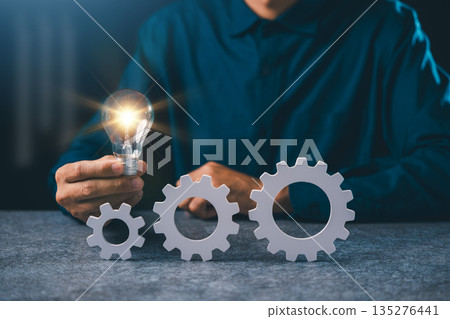 Light ideas concept project business gear management improves, manager supervises devops process automation deploy while professional holds glowing bulb near white gears for growth Light ideas concept project business gear management improves, manager supervises devops process automation deploy while professional holds glowing bulb near white gears for growth 135276441