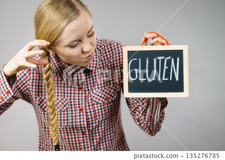 Angry woman holding board with gluten sign 135276785