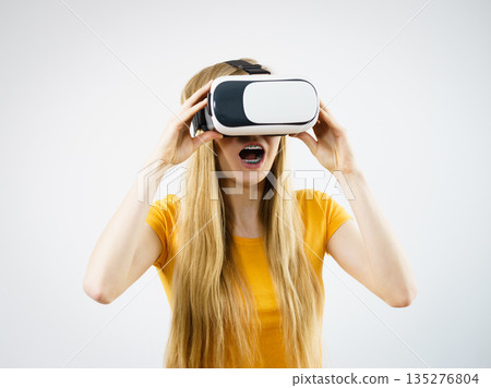 Girl wearing virtual reality goggles. 135276804