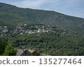 panoramic view village mountainous landscape towards the Gulf of Porto in sunlight with blue skies and spectacular cloud 135277464