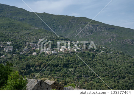 panoramic view village mountainous landscape towards the Gulf of Porto in sunlight with blue skies and spectacular cloud panoramic view village mountainous landscape towards the Gulf of Porto in sunlight with blue skies and spectacular cloud 135277464