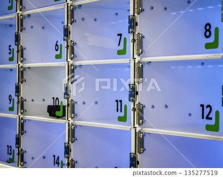 Lockers in a storage facility with numbers and a blue display light 135277519