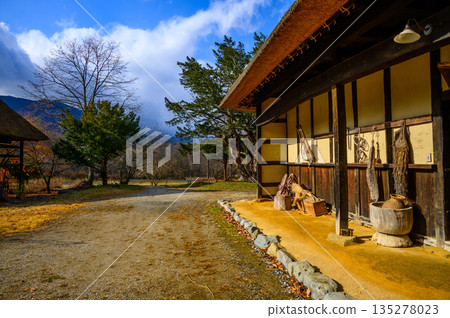 The curved thatched roof of Yajuro-don's Nambu Magari-ya house in Tono Furusato Village in late autumn 135278023