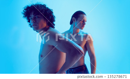 Two young men side view with alert posture in blue light. 135278671