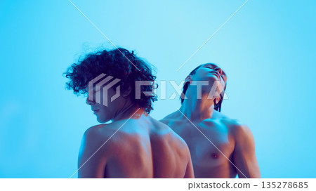 Two young men back view with closed eyes in blue light. Two young men back view with closed eyes in blue light. 135278685
