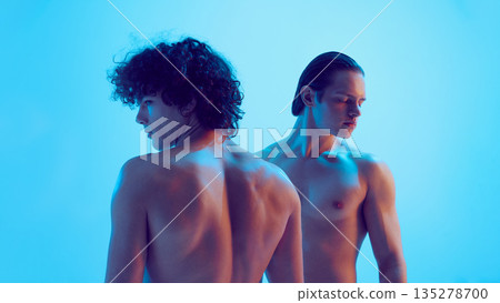 Two young men back view with emotional contrast in blue light. Two young men back view with emotional contrast in blue light. 135278700