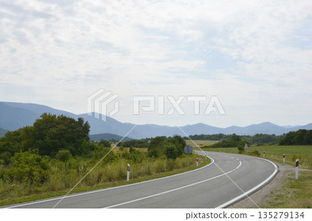 Winding asphalt road through Lika mountains in Croatia 135279134