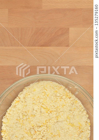 Crumbled cookie dough in glass bowl on wooden background Crumbled cookie dough in glass bowl on wooden background 135279160