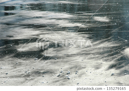 Windblown snow on frozen lake ice 135279165