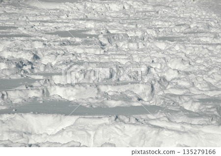 Deep footprints and tracks in fresh white snow 135279166