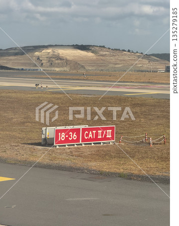 Airport runway category sign near taxiway. Flight navigation, landing systems, and aviation safety through airfield infrastructure Airport runway category sign near taxiway. Flight navigation, landing systems, and aviation safety through airfield infrastructure 135279185