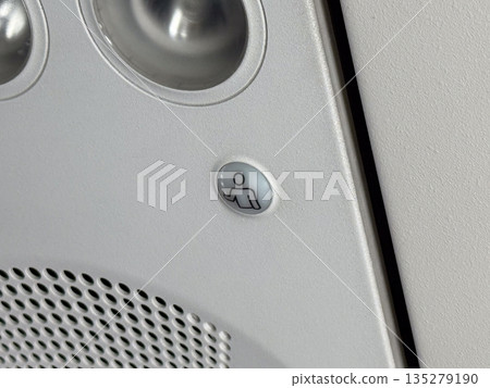 Passenger call button on aircraft ceiling panel. Inflight service, communication, and cabin assistance through aviation interface design 135279190