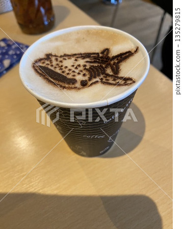A cafe latte in a takeaway cup with whale latte art 135279815