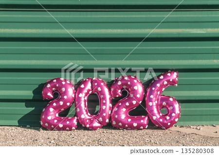 pink number 2026 balloons against a green wall pink number 2026 balloons against a green wall 135280308
