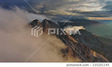 Amazing rocky mountains in clouds at sunset 135281145
