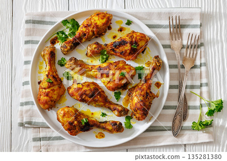 roasted chicken drumsticks on a white plate 135281380