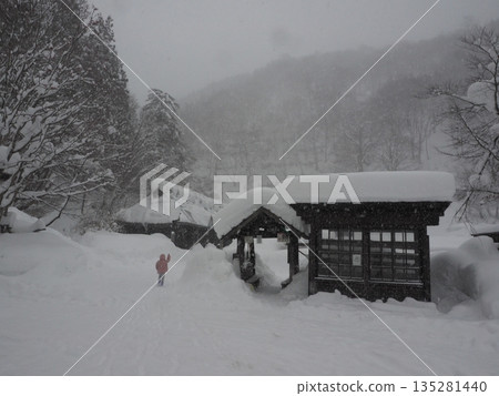 在暴風雪肆虐的山區村莊,一座傳統的日式房屋被厚厚的積雪掩埋,能見度極低。 在暴風雪肆虐的山區村莊,一座傳統的日式房屋被厚厚的積雪掩埋,能見度極低。 135281440