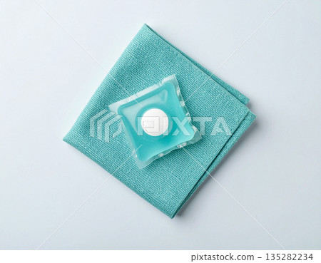 How-to cleaning blogs. Soluble laundry detergent capsule on a neutral linen cloth with empty space for text. How-to cleaning blogs. Soluble laundry detergent capsule on a neutral linen cloth with empty space for text. 135282234