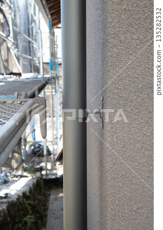 Vertical gutters being installed along the wall Vertical gutters being installed along the wall 135282532