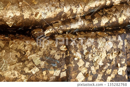 Golden Leaf Foil on Sacred Buddhist Buddha Statue 135282768