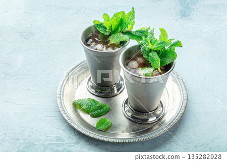 Mint Julep in the Kentucky Derby classic silver glass, with fresh mint leaves Mint Julep in the Kentucky Derby classic silver glass, with fresh mint leaves 135282928