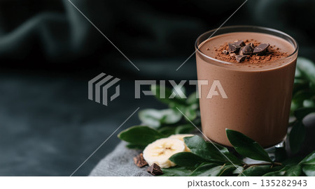 glass of chocolate smoothie with cocoa powder, banana slices, and a sprinkle of cacao nibs	 135282943