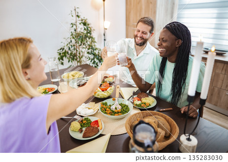 Friends enjoy a bright dinner at home 135283030