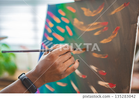 Artist in cozy studio paints vibrant colors Artist in cozy studio paints vibrant colors 135283042
