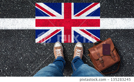 Traveler Standing On Union Jack Flag Marking British Travel, Passport, And Casual Backpack. 135283245