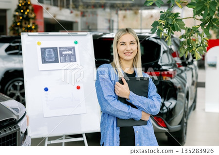 Saleswoman showing infographic during presentation about automotive suspension performance in car dealership Saleswoman showing infographic during presentation about automotive suspension performance in car dealership 135283926