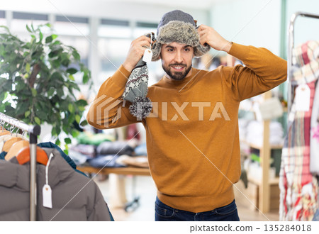 Young man choosing hat in clothing store 135284018