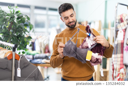 Man choosing a set of underwear for his wife 135284032