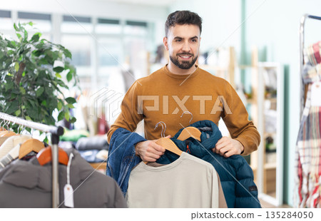 Young man doing shopping in clothing store 135284050
