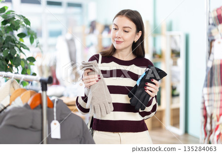 Young woman choosing gloves in clothing store Young woman choosing gloves in clothing store 135284063