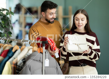 Couple choosing a fashionable handbag together in a European store 135284220