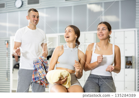 Guy attempting to join conversation with laughing girls in gym locker room Guy attempting to join conversation with laughing girls in gym locker room 135284389