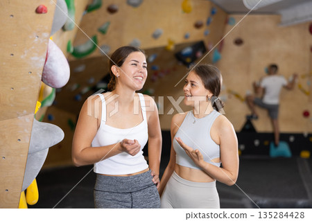 Two young women talking near climbing wall 135284428