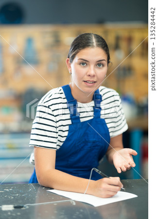 Female bicycle repair service worker signing document 135284442
