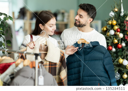 In store, couple customer choose winter jacket, X mas shopping In store, couple customer choose winter jacket, X mas shopping 135284511