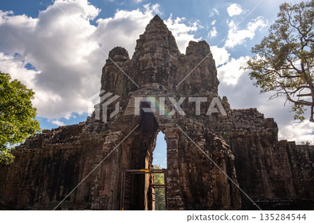 The face tower on the south gate to Angkor Thom the ancient capital city of Khmer empire in Siem Reap, Cambodia.  135284544