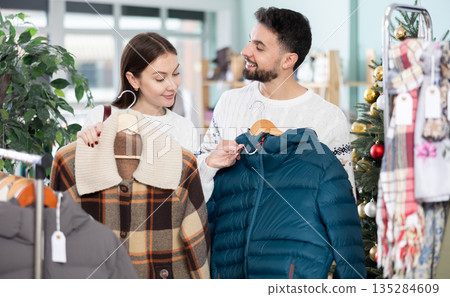 In store, couple customer choose winter jacket, X mas shopping In store, couple customer choose winter jacket, X mas shopping 135284609