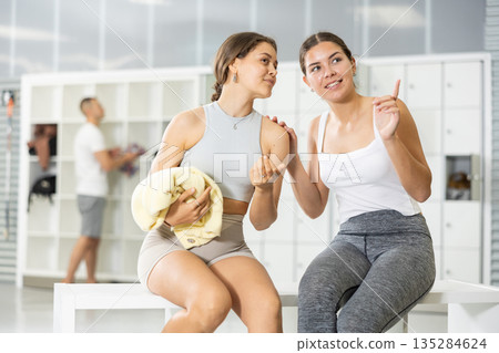 Female friends enjoying conversation in locker room of climbing gym Female friends enjoying conversation in locker room of climbing gym 135284624