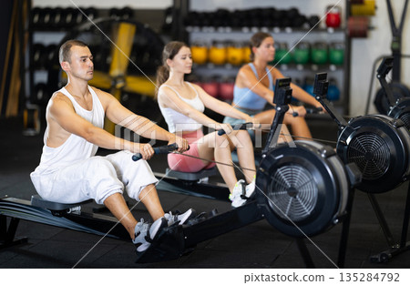 Sportsman training at cable row machine in modern crossfit gym Sportsman training at cable row machine in modern crossfit gym 135284792