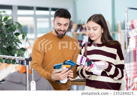Couple choosing a set of socks in a European store Couple choosing a set of socks in a European store 135284825