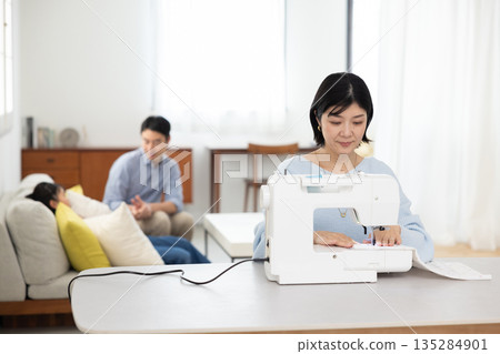 一位中年婦女在客廳縫紉 135284901