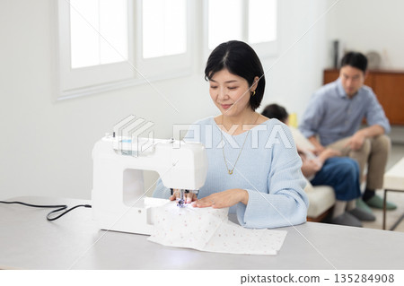 一位中年婦女在客廳縫紉 135284908